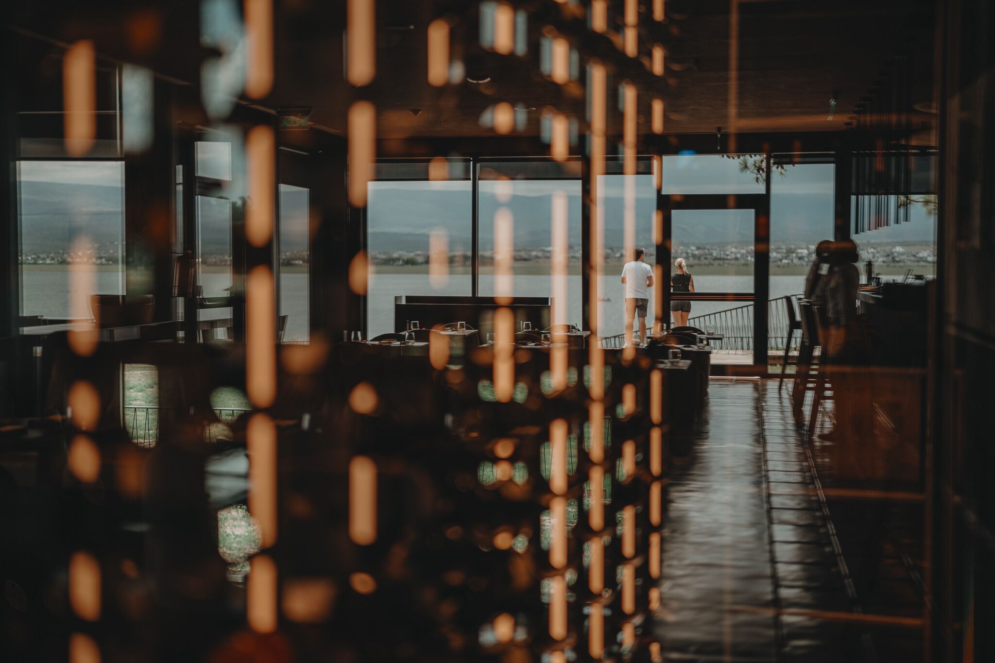 A spacious indoor area with large windows overlooking a body of water.
