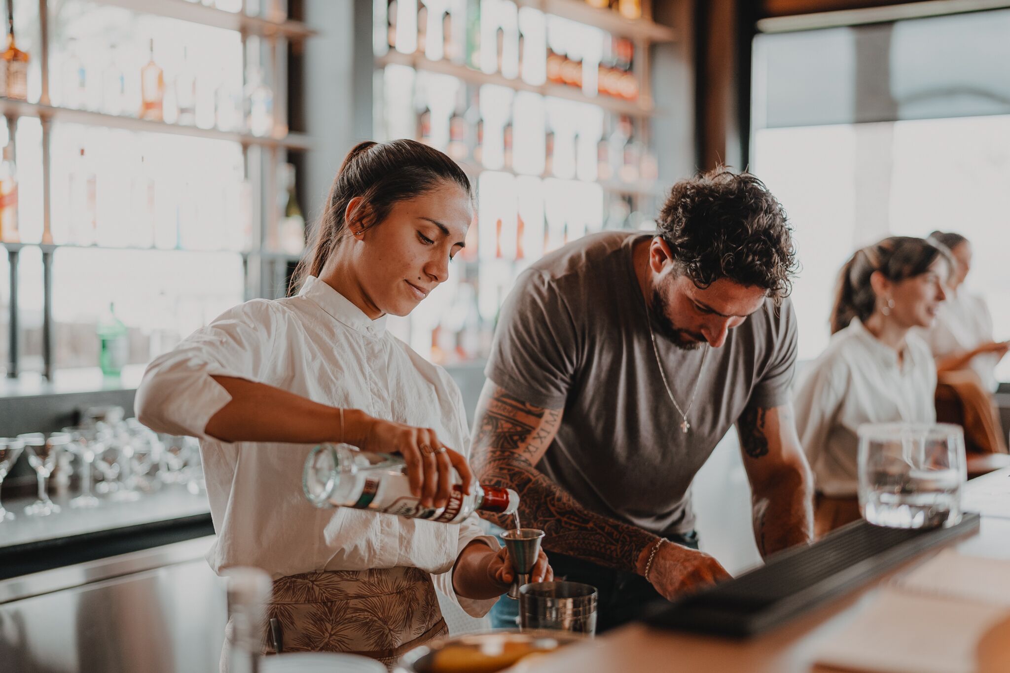 Um bar com um bartender preparando uma bebida.