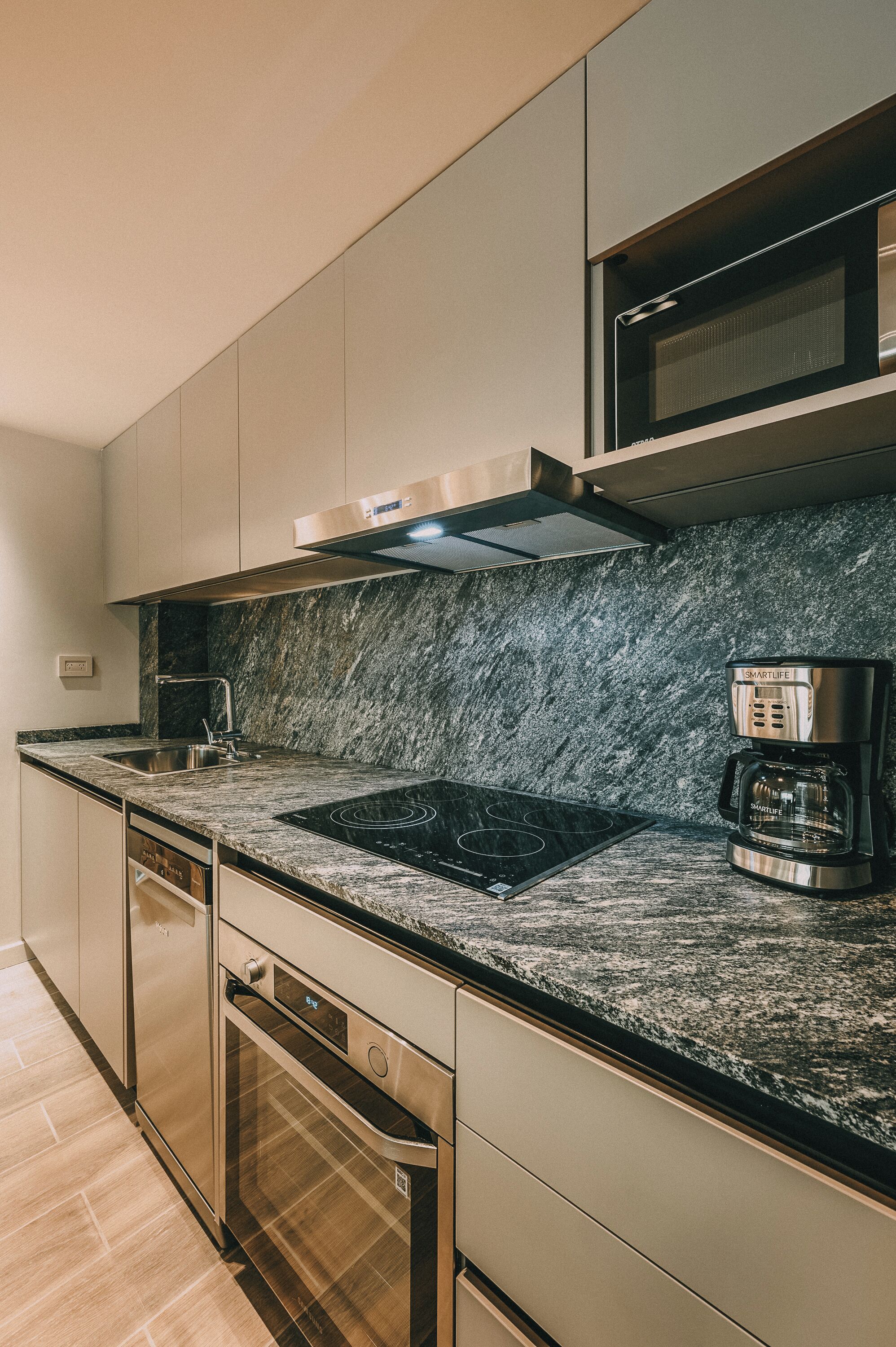 A modern kitchen with a built-in stove, microwave, and coffee maker.