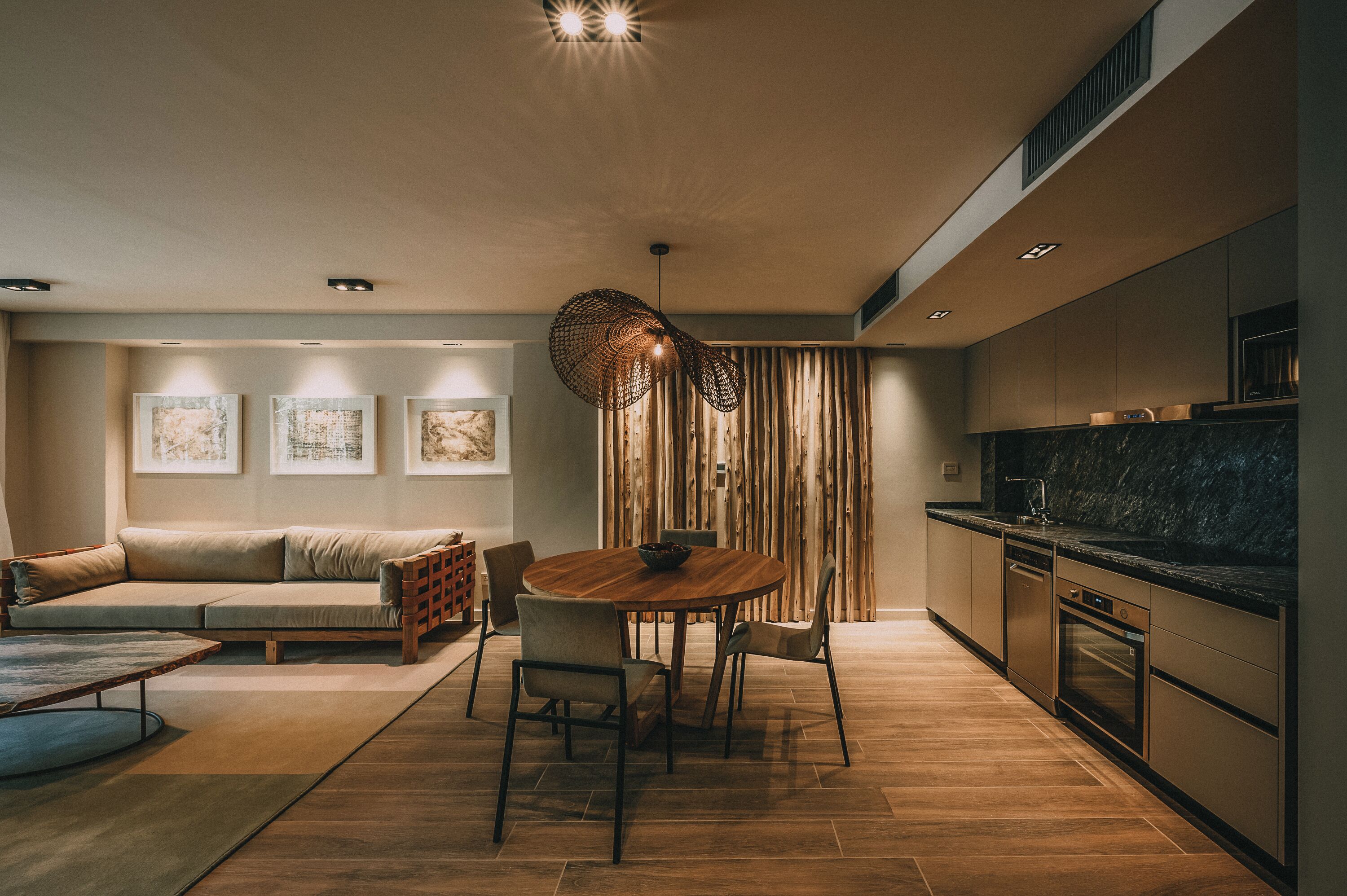 Un salon moderne avec une table ronde en bois, un canapé et un coin repas.