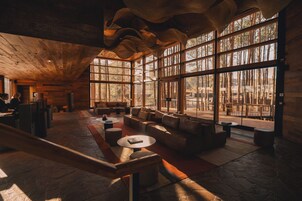 Un vestíbulo amplio con techo alto y ventanas grandes, que ofrece vistas al exterior.