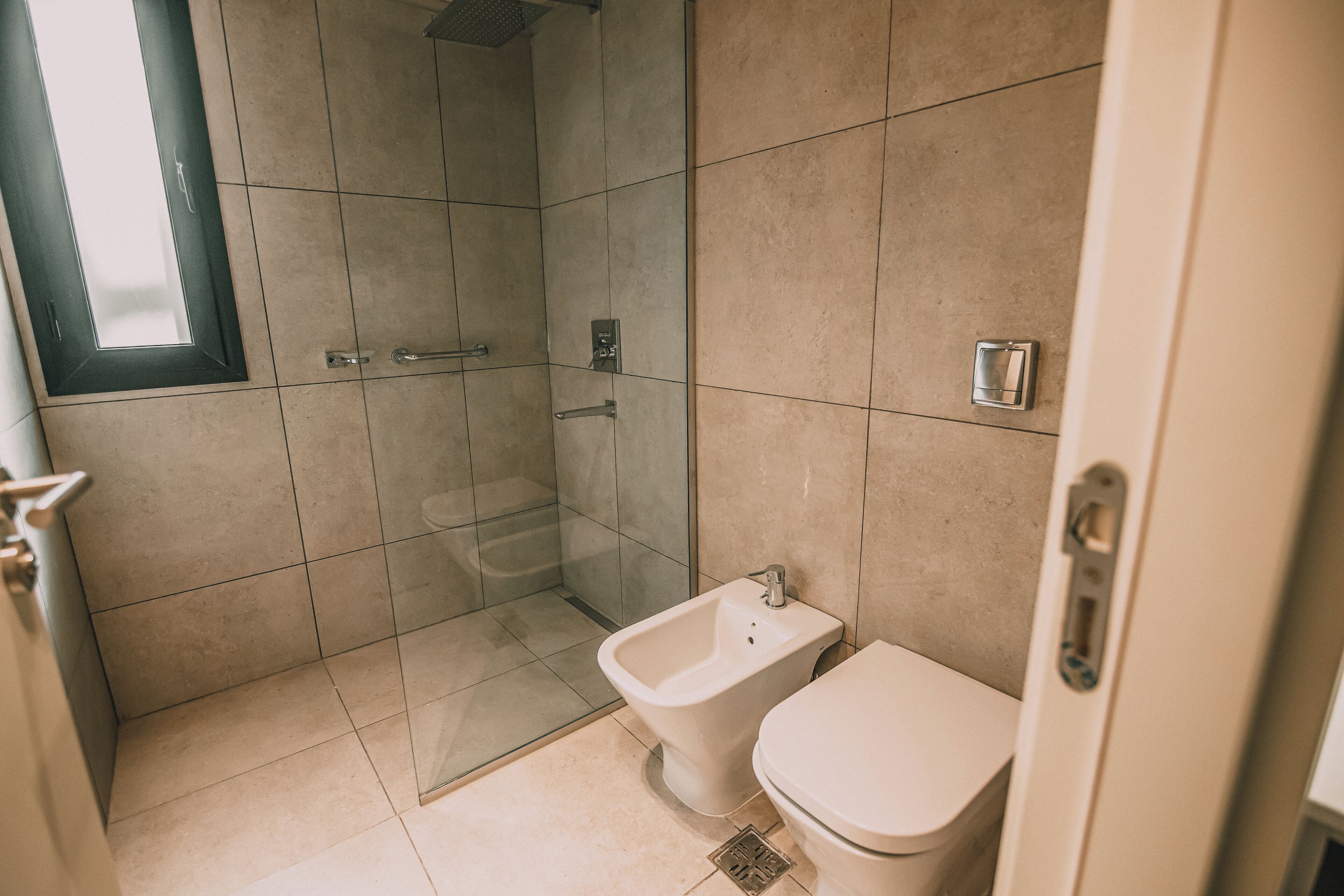 Une salle de bain équipée d’une douche, d’un bidet et de toilettes.