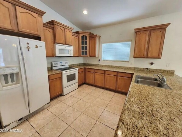 Enjoy cooking in this well-equipped kitchen with a refrigerator, microwave, stove, and sink.