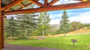 Una terraza de madera con vistas a un paisaje verde y árboles.