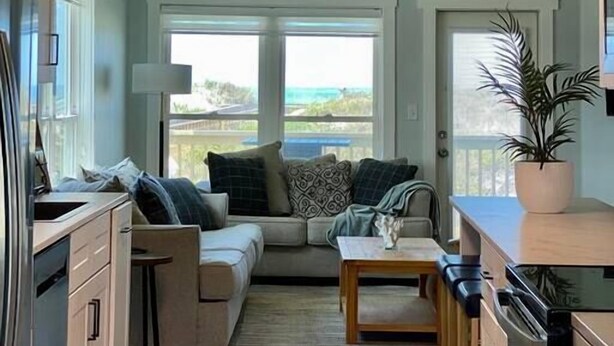A modern kitchen with a large window, a built-in bench, and a hanging light fixture. - Sublime Sunset☀️ Ocean Front Getaway (Port St. Joe)