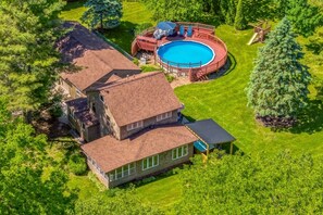 A large house with a swimming pool, a covered deck, and a fenced yard.