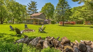 A house with a porch, a lawn, and a pile of firewood. - Riverfront, swimming pool, hot tub, pickleball court, basketball, billiard (Lyndon)