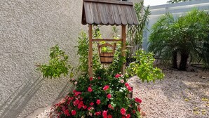 Een tuin met een houten vogelhuisje en een hangmand.