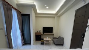 Habitación de hotel con dos camas, un televisor, una mesita y una silla.