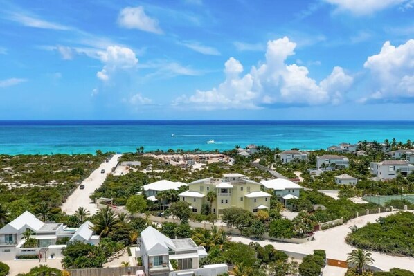 A coastal resort with multiple buildings, a clear view of the ocean, and a well-maintained landscape.
