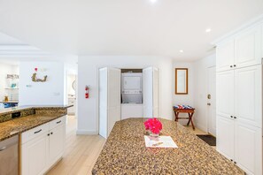 A modern kitchen with granite countertops, a central island, and a built-in oven. - Stunning Yacht Club, Walk To Beach, Great Reviews! (Turtle Cove)