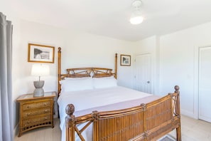 A room with a bed, a bedside table with a lamp, and two framed pictures on the wall. - Stunning Yacht Club, Walk to Beach, Great Reviews! (Turtle Cove)