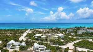 Ein Küstenwohngebiet mit modernen Häusern, einem Strand und freiem Blick auf den Ozean.
