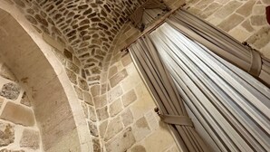 A stone ceiling with a unique pattern, a large column, and a hanging curtain. - Ana Talia House (Mardin)