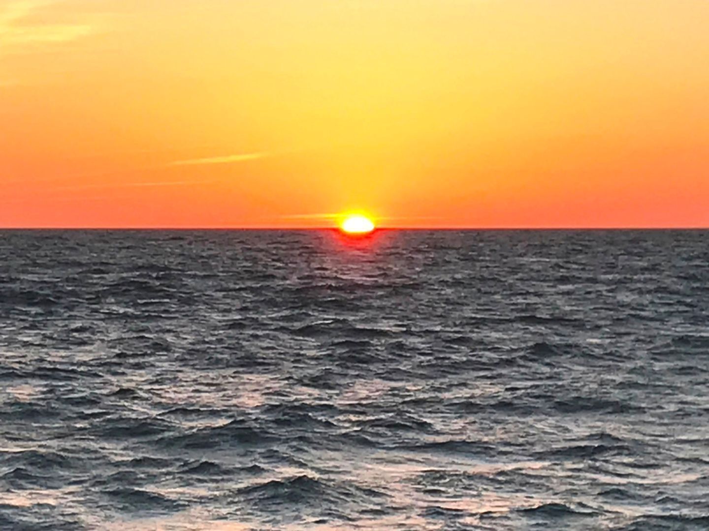 Un coucher de soleil sur l’océan, sans terre en vue.