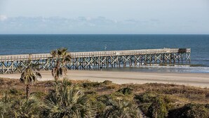 A pier extending into the ocean with a sandy beach in the foreground and palm trees. - 3rd Floor Condo w/Amazing Ocean Views! Pool & Pier Access! In Heart of IOP! *Unit 321* (Isle Of Palms)