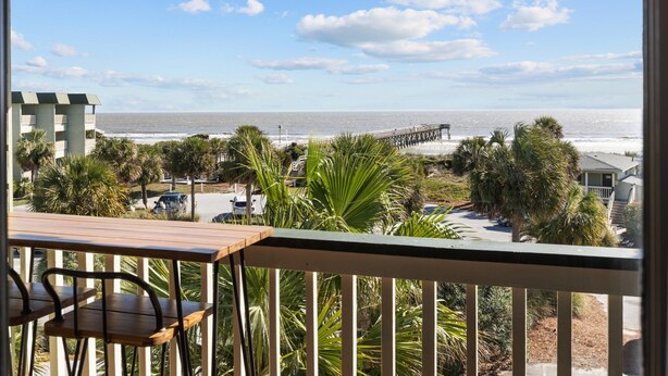 A balcony with a view of the ocean, palm trees, and a pier. - 3rd Floor Condo w/Amazing Ocean Views! Pool & Pier Access! In Heart of IOP! *Unit 321* (Isle Of Palms)