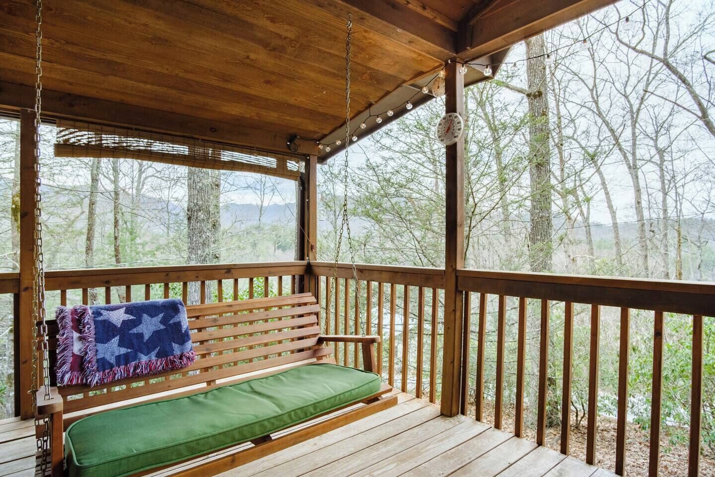 Une terrasse en bois avec un banc et une horloge suspendue.