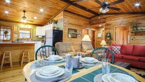 Ein gemütliches Blockhaus-Interieur mit Essbereich, Küche und Wohnbereich.