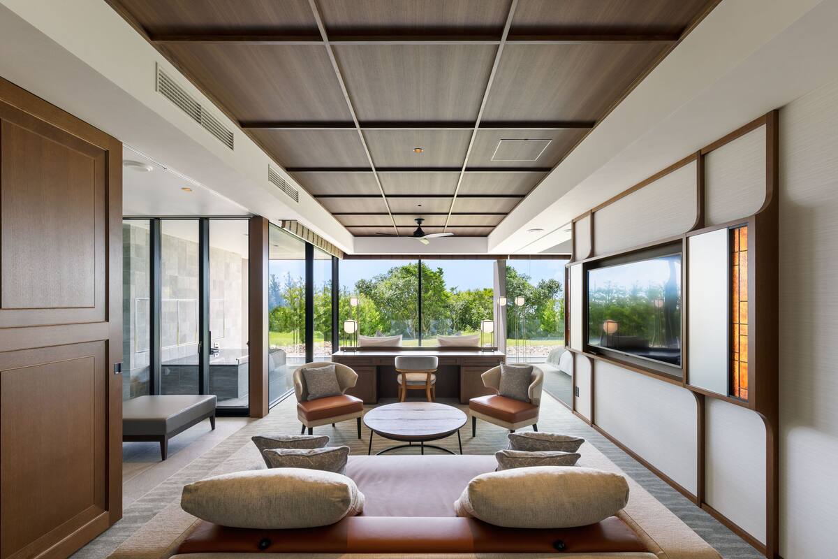 A modern interior with a sofa, chairs, a dining table, and a TV.