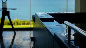 A view from a balcony with a table and chairs, overlooking a body of water and greenery. - GOTO RETREAT by Onko Chishin (Goto)