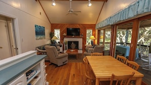 A cozy living room with a fireplace, wooden furniture, and a television.