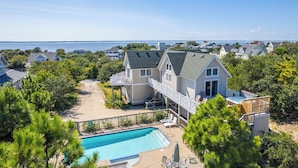 A residential property with a swimming pool, a deck, and a view of the ocean.