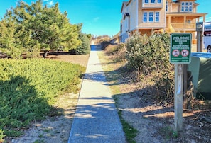 A pathway leading to a building with a sign welcoming beach access for Southern Shores residents and guests.