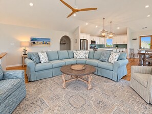 A modern living room with a sectional sofa, a wooden coffee table, and a patterned rug.