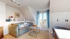 Un salon moderne avec un canapé, une table basse et une vue sur l’extérieur grâce à de grandes fenêtres.