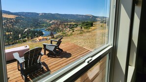 A deck with two chairs overlooking a scenic landscape including a river and hills. - Grandview Getaway offers spectacular views overlooking the Clearwarter river. (Lenore)