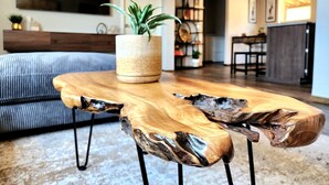 A modern living room with a wooden coffee table, a sofa, and a potted plant. - Grandview Getaway offers spectacular views overlooking the Clearwarter river. (Lenore)