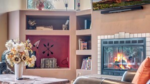A cozy living room with a fireplace, bookshelves, and a coffee table with a vase of flowers. - Experience luxury at Sedona Garden Oasis at Bell Rock, perfect for families! (Sedona)