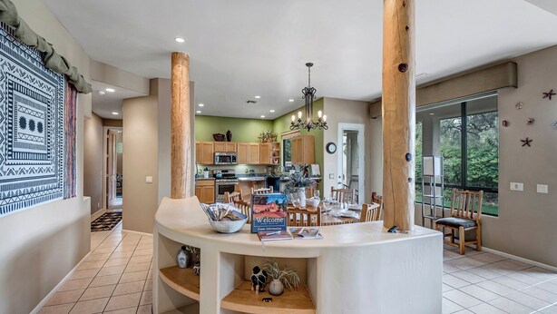 A modern kitchen with wooden cabinets, a dining area with a table set for four, and a large window offering a view of the outdoors. - Experience luxury at Sedona Garden Oasis at Bell Rock, perfect for families! (Sedona)