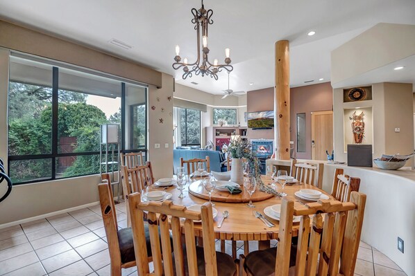 Comedor con una mesa redonda de madera dispuesta para seis comensales, rodeada de sillas de madera.
