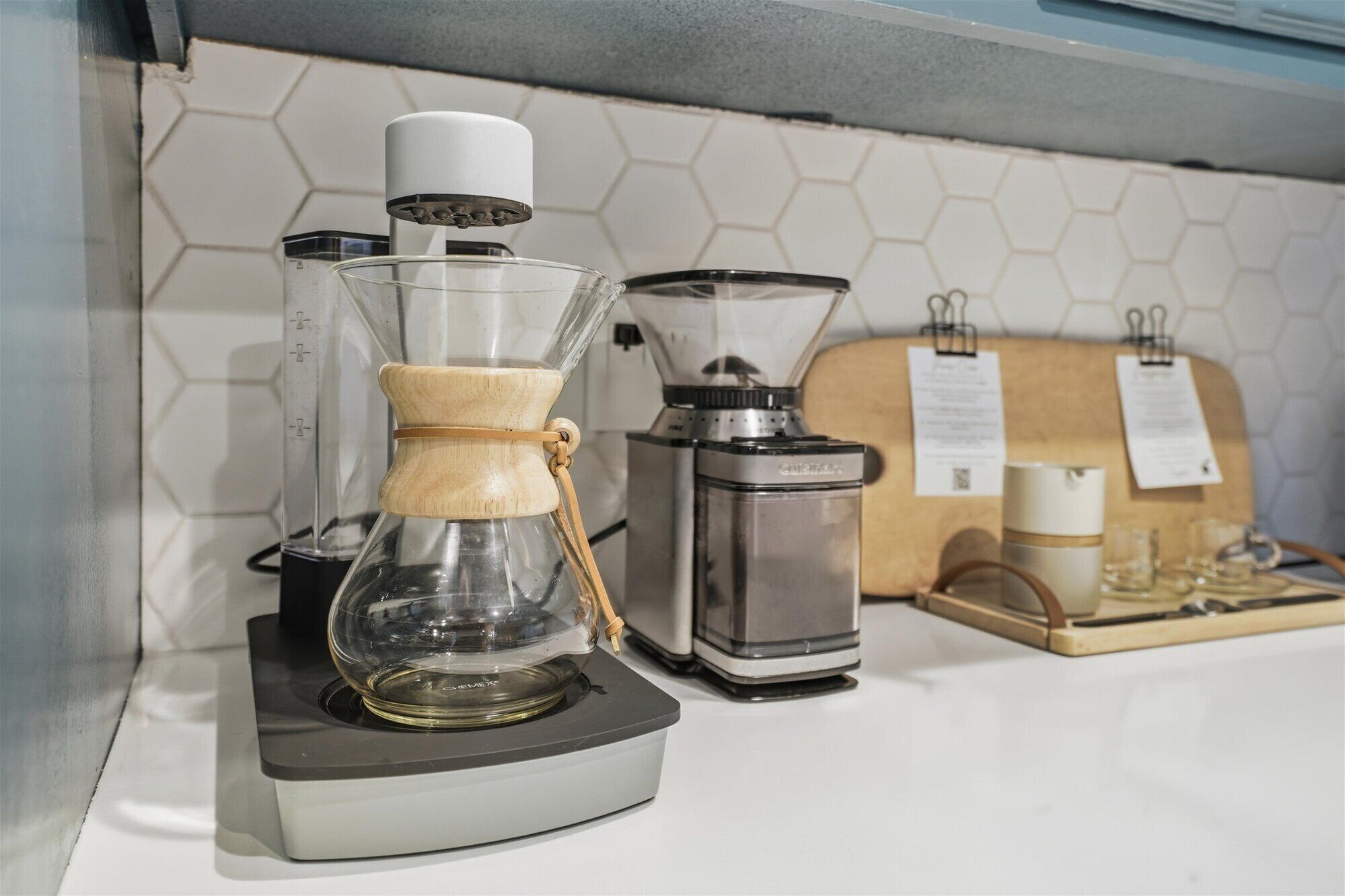 Une machine à café, un moulin à café et un grille-pain sont posés sur un plan de travail.