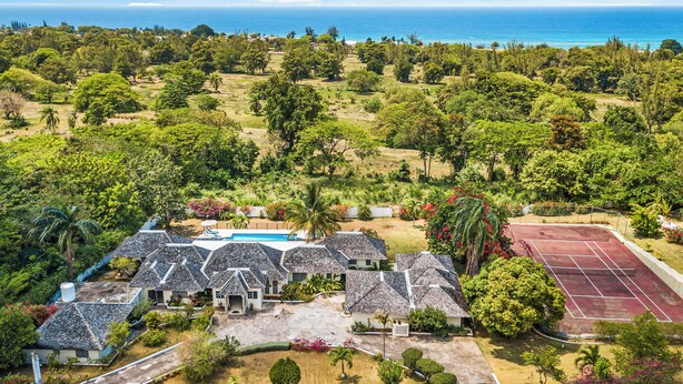 A residential area with multiple houses, a swimming pool, and a tennis court. - Forever Summer Gorgeous 4BDR Villa (Runaway Bay)