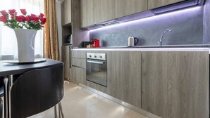 A modern kitchen with wood paneling, stainless steel appliances, and a built-in oven.