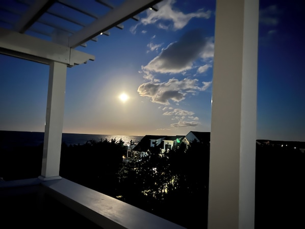 Un balcón con vista al atardecer sobre un barrio residencial.