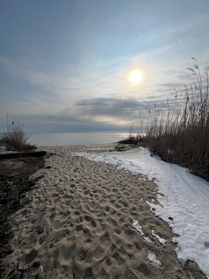 A beach with a sandy path leading to the water, surrounded by grass and reeds. - Hidden Gem, Relax,Water Views, Covered Deck Breezes Elevator &HotTub&Turf Fields (Milford)