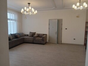 Relax in this spacious living area with a large L-shaped sofa and two chandeliers.