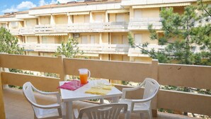 Una terrazza con tavolo e sedie, un boccale di succo d'arancia e un tovagliolo rosa.