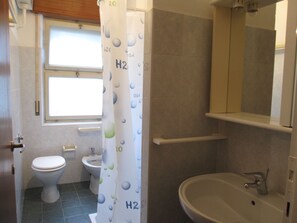 A bathroom with a toilet, bidet, and sink.