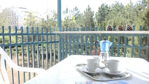 A balcony with a table set for two, a blue coffee pot, and a magazine. - One-bedroom Flat Next to Bibione Thermae (San Michele al Tagliamento)