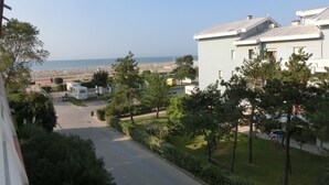 A residential area with a view of the sea, featuring houses, a road, and parked RVs. - Nice Flat for six Guests by the sea (San Michele al Tagliamento)