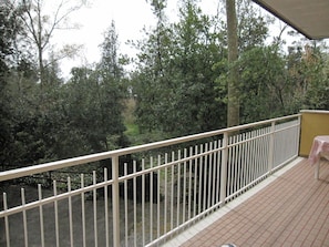 Un balcon avec une balustrade blanche, une table et des chaises.