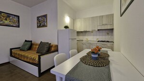 A compact living space with a sofa, a dining table, and a kitchenette. - Enjoy Your Stay Only 100mt From the sea - Beahost (San Michele al Tagliamento)