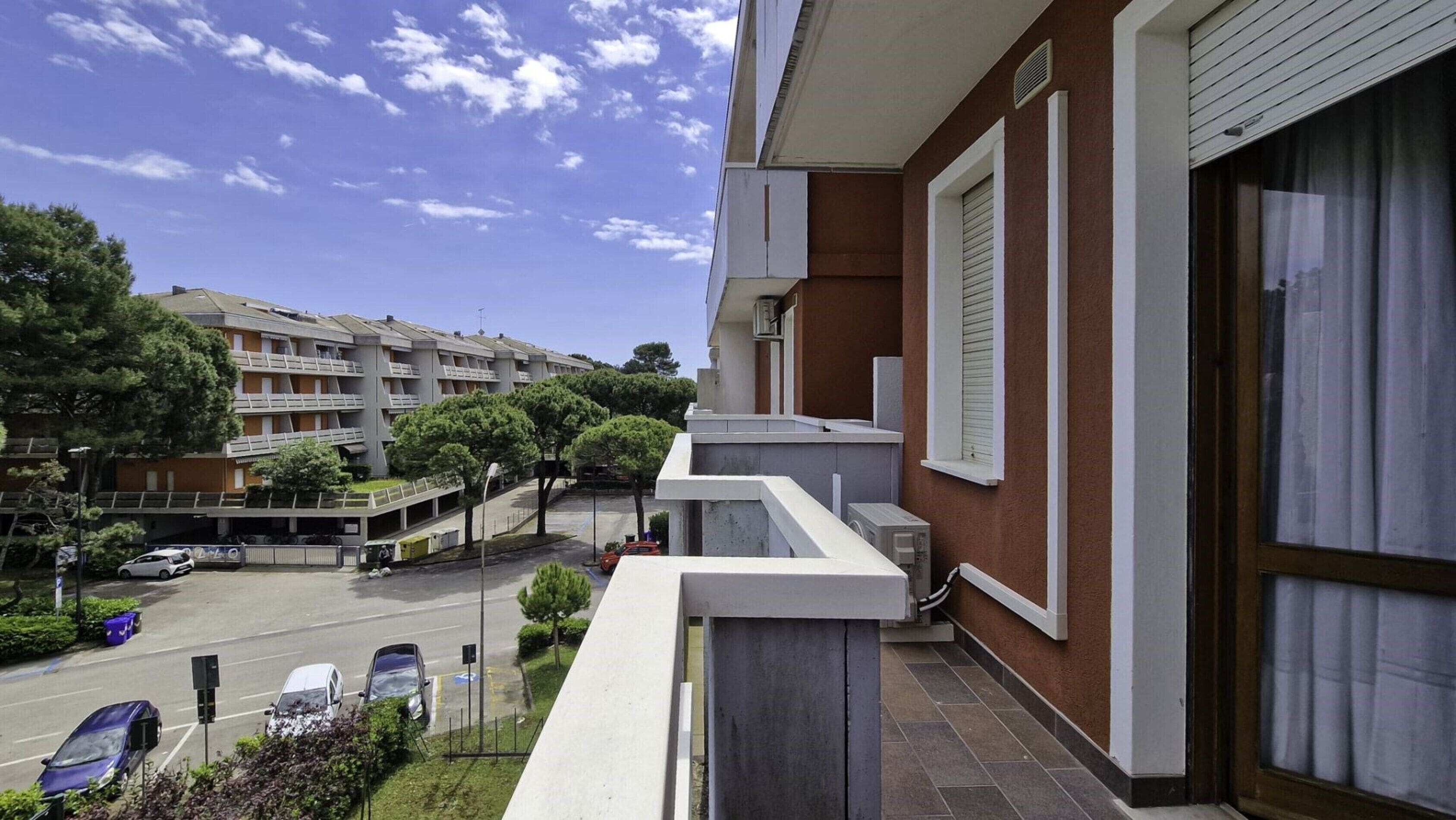 A residential building with a balcony overlooking a street.