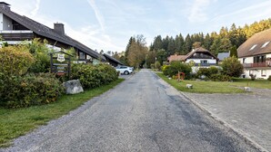A rural road leading to a row of traditional houses with visible signage indicating a sauna.