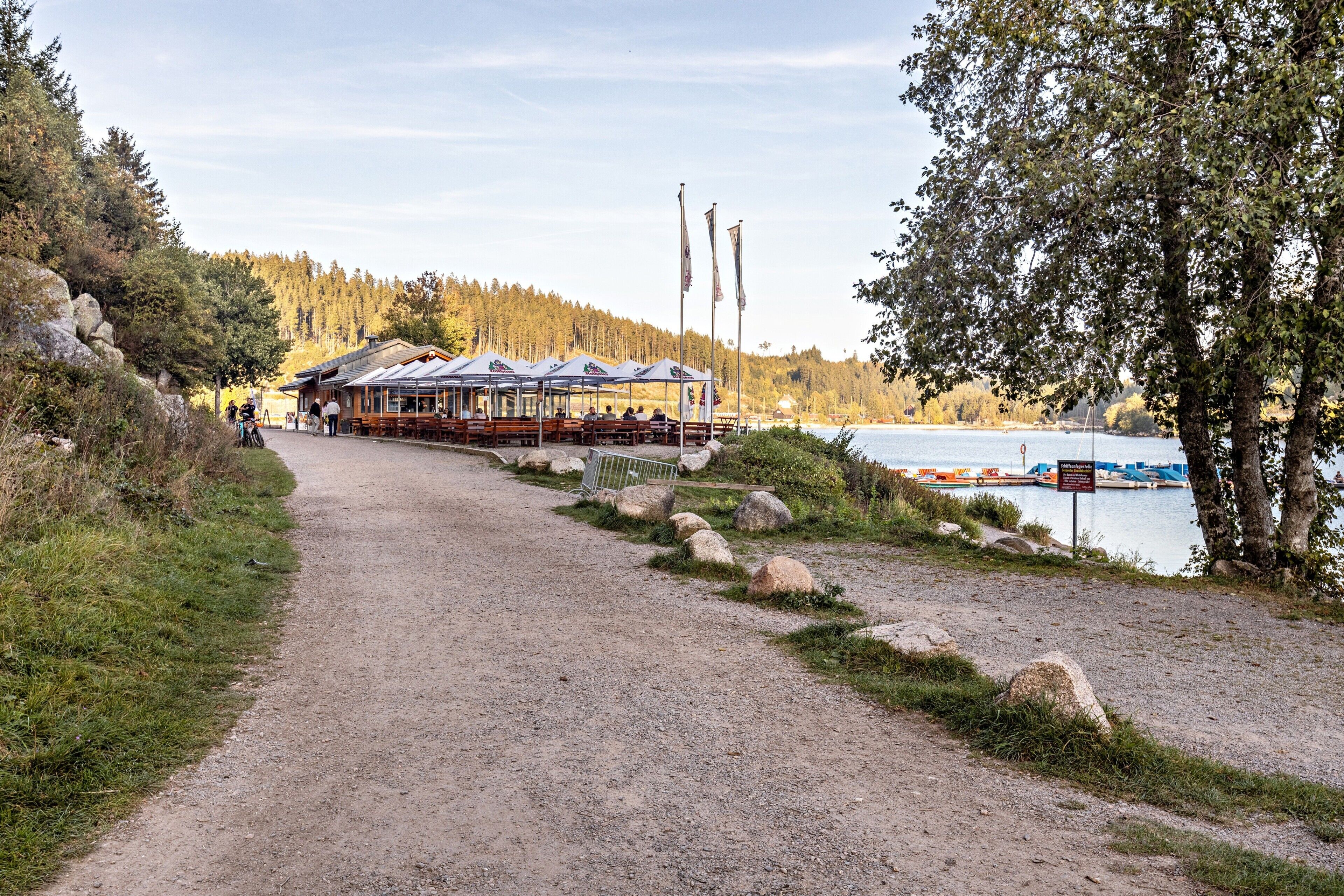 Ein Flussufer-Lodges mit Außenbestuhlung, einem Steg und bewaldeter Umgebung.
